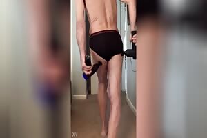 Double Massage Gun pain relief standing in black and red briefs